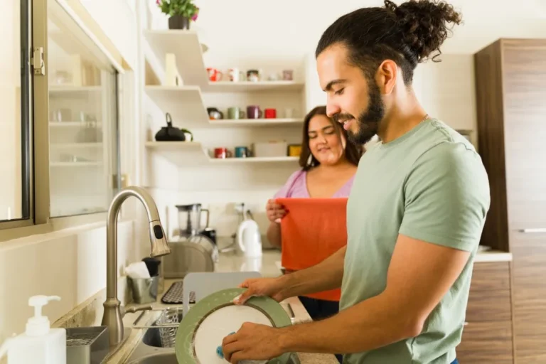 Two support workers doing the dishes at home